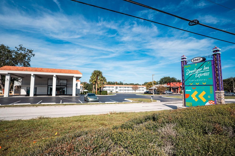 Hotel parking lot and building with sign in front